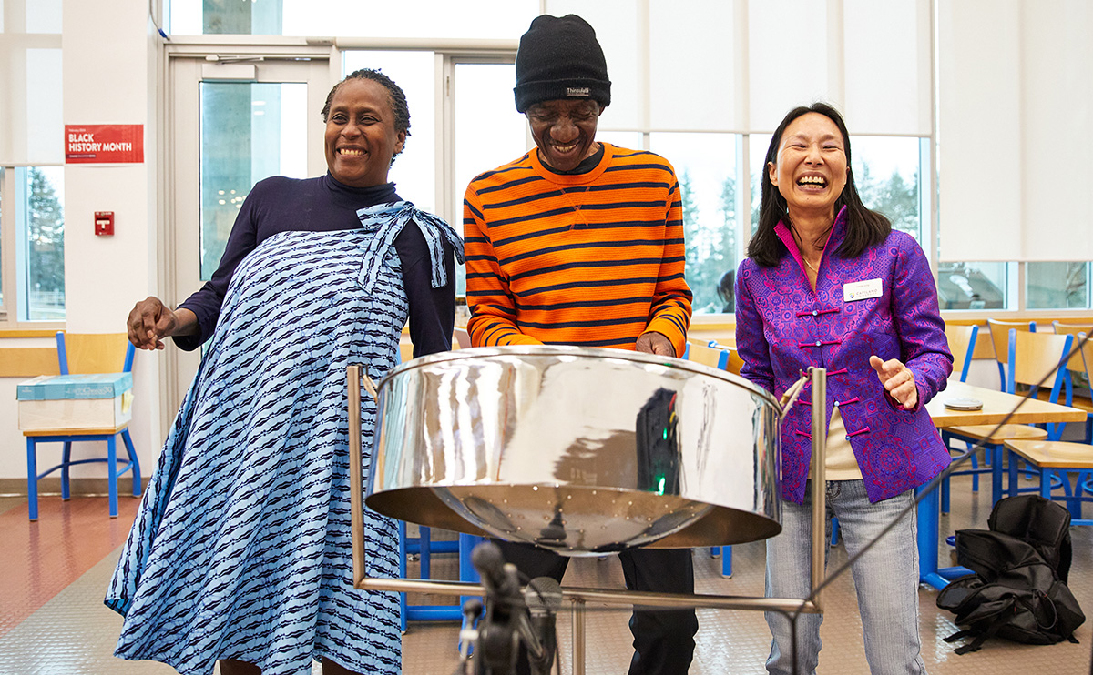Instructors Susan Romeo-Gilbert and Carrie Jung with steel pan musician Anthony Blackman