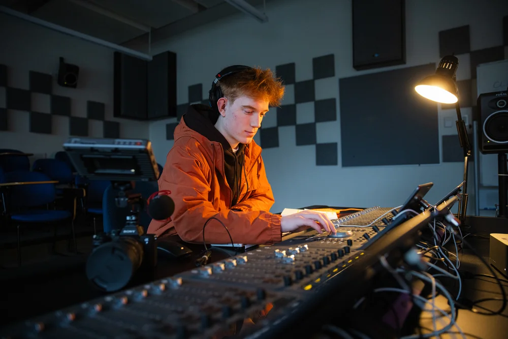 Cameron Johnson working the audio mixing board in CapU's media production lab