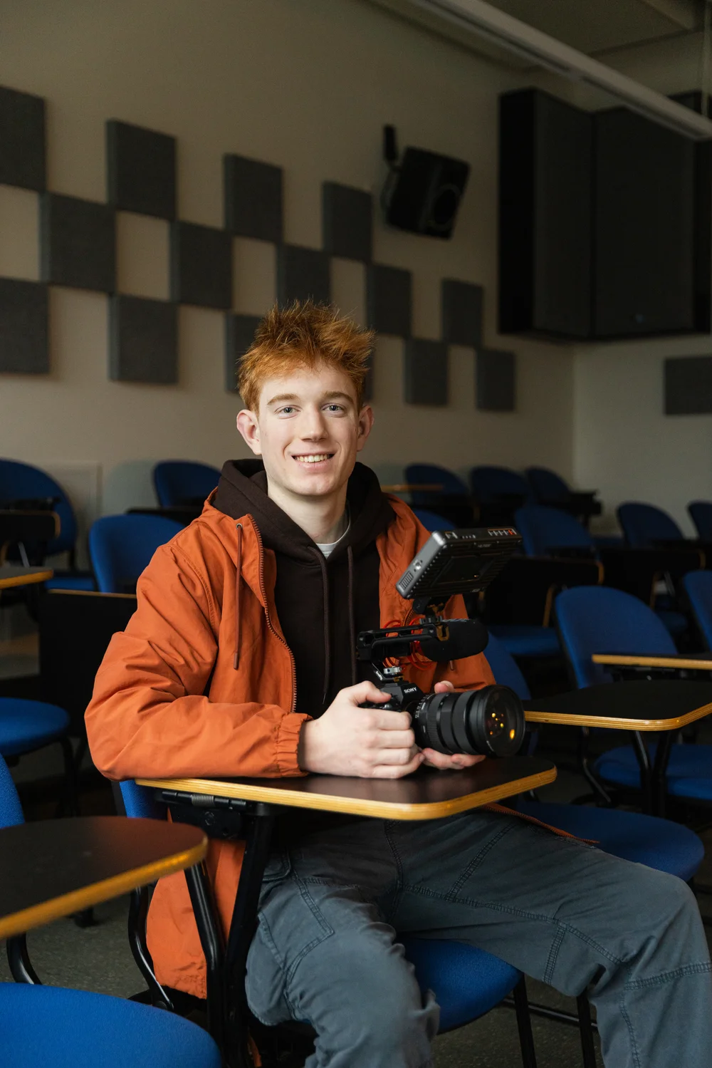 Cameron Johnson, Bachelor of Motion Picture Arts student, holding a camera rig in a CapU media production classroom