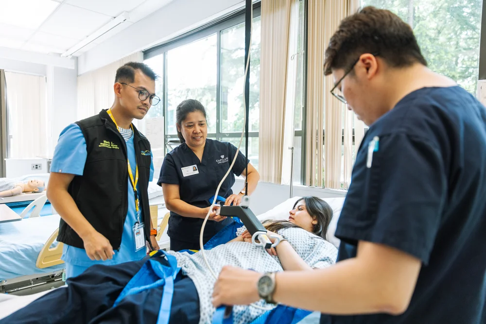 A Health Care Assistant student caring for a patient in a CapU lab