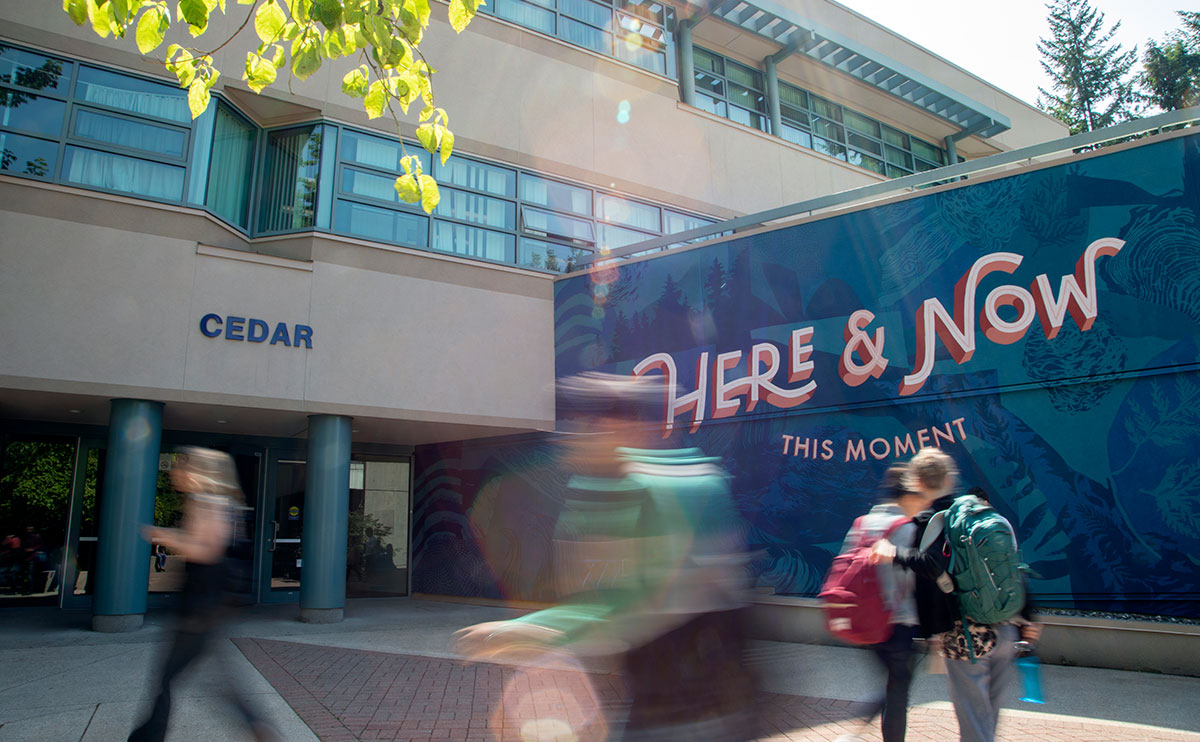 Students in front of the Here & Now mural on the Cedar Building