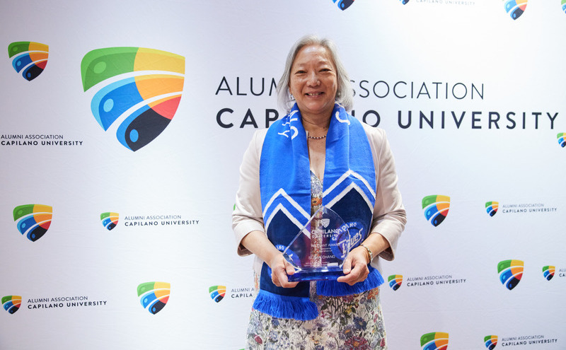 CapU alumni Dr. Susan Chang with her Alumni Award of Excellence statue.