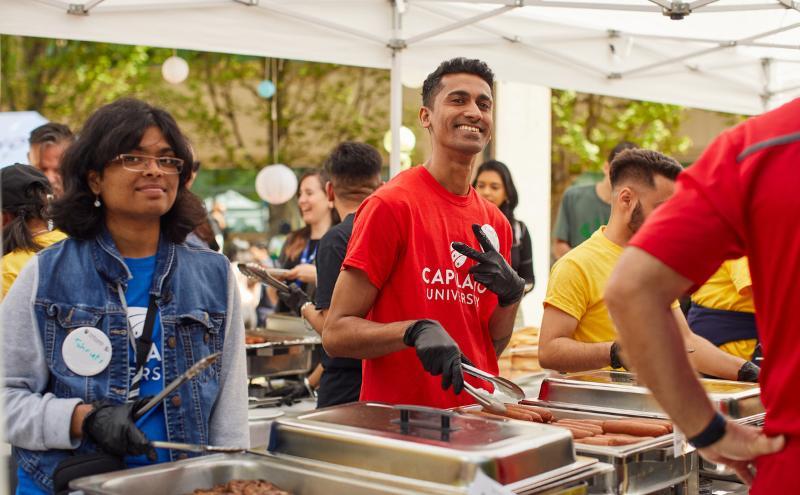 Volunteers serving food at 2023 new student summer orientation