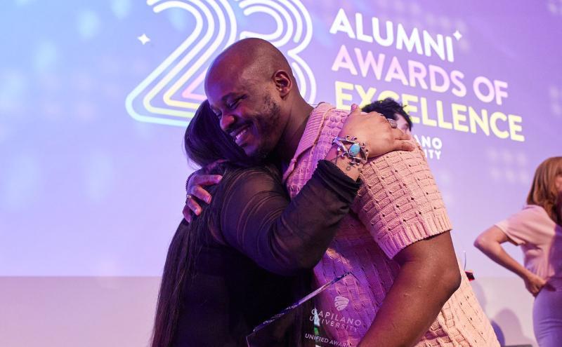 An alumni award recipient receiving their award