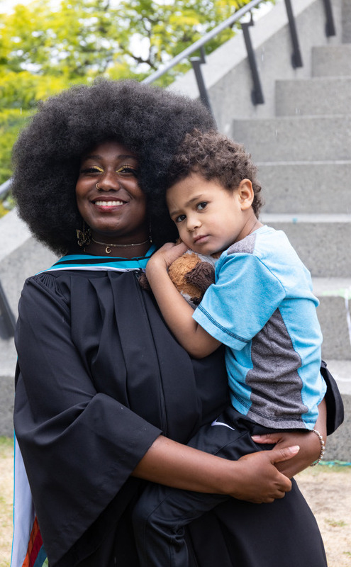 Student celebrating at Convocation 2023 with child