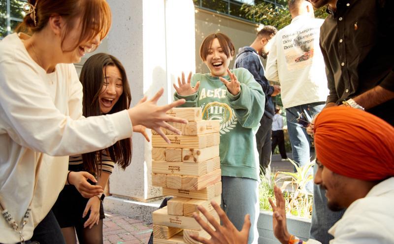 Students gathering for a game of Jenga at Captivate