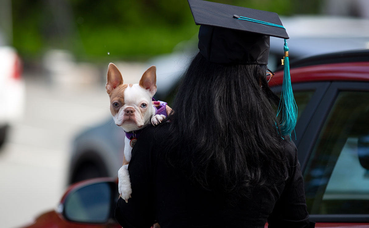 Student holding dog at ceremony