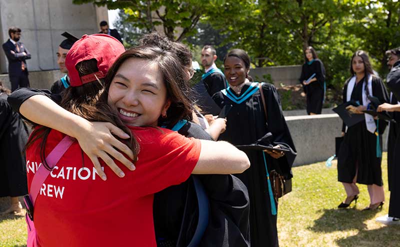 Graduating student hugging a Convocation volunteer.