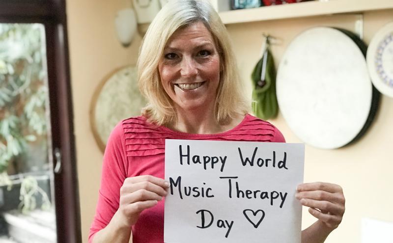 Esther Thane with sign for World Music Therapy Day