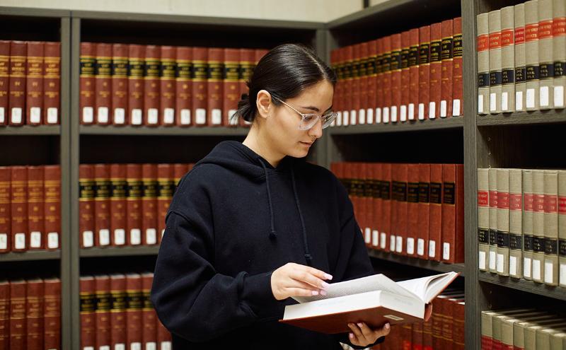 Student in library holding book