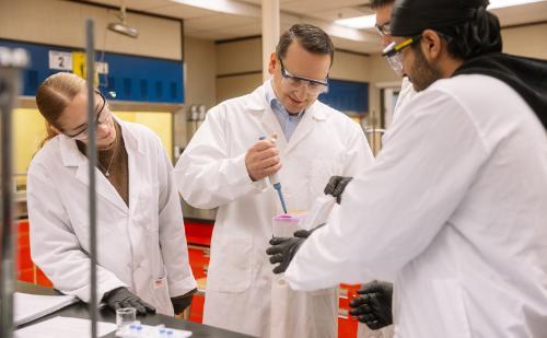 CapU president Dr. Jason Dewling in a lab with students. 