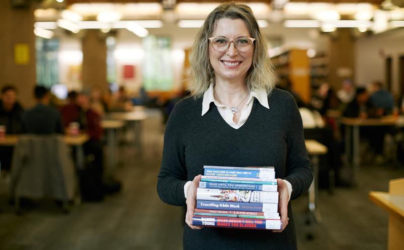 Cathy Mount holding stack of books