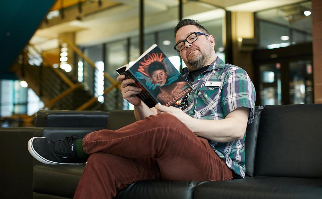 Staff reading book in library