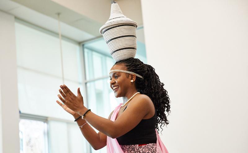 Angelique, a dancer from the Indangamirwa Traditional Dance Group, performing in the Birch Cafeteria