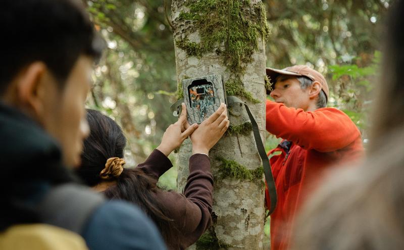 Instructor Thomas Flower teaching students how to set up motion detector cameras at the Howe Sound Biosphere.