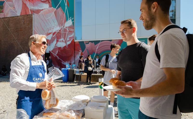 CapU President Paul Dangerfield serves up burgers to students on the beautiful sunny day.