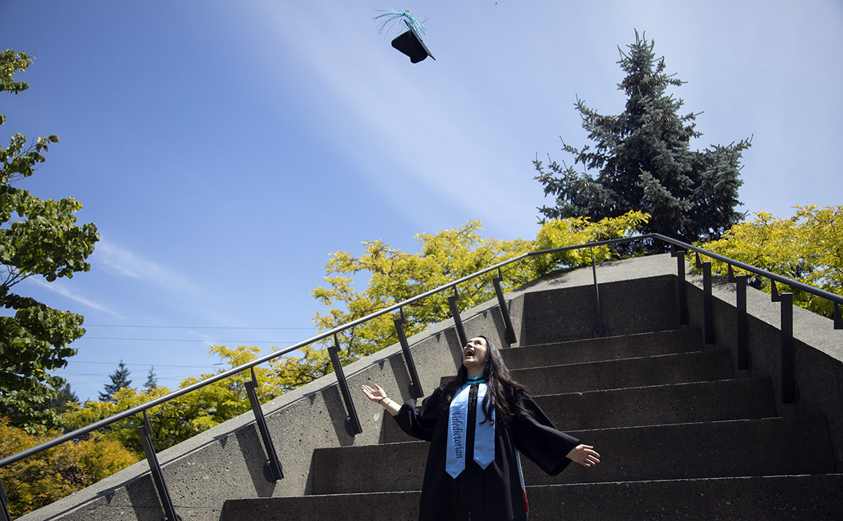 Dini Stamatopulos throwing graduation cap in the air