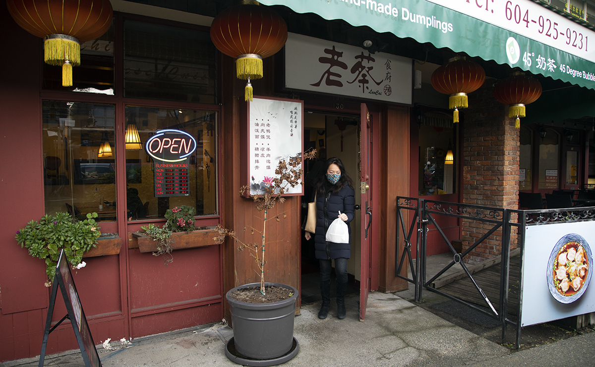 Karen Yip walking out of a Chinese restaurant with a bag of food