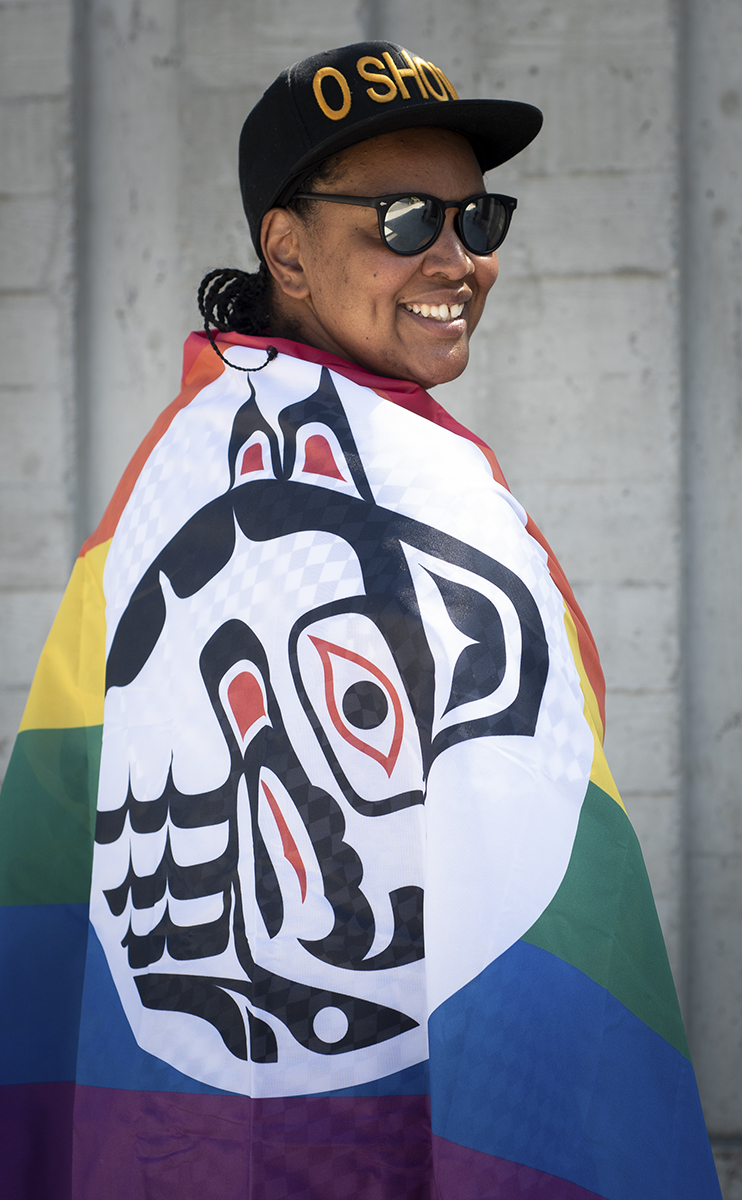 Orene Askew wearing pride flag with Indigenous art