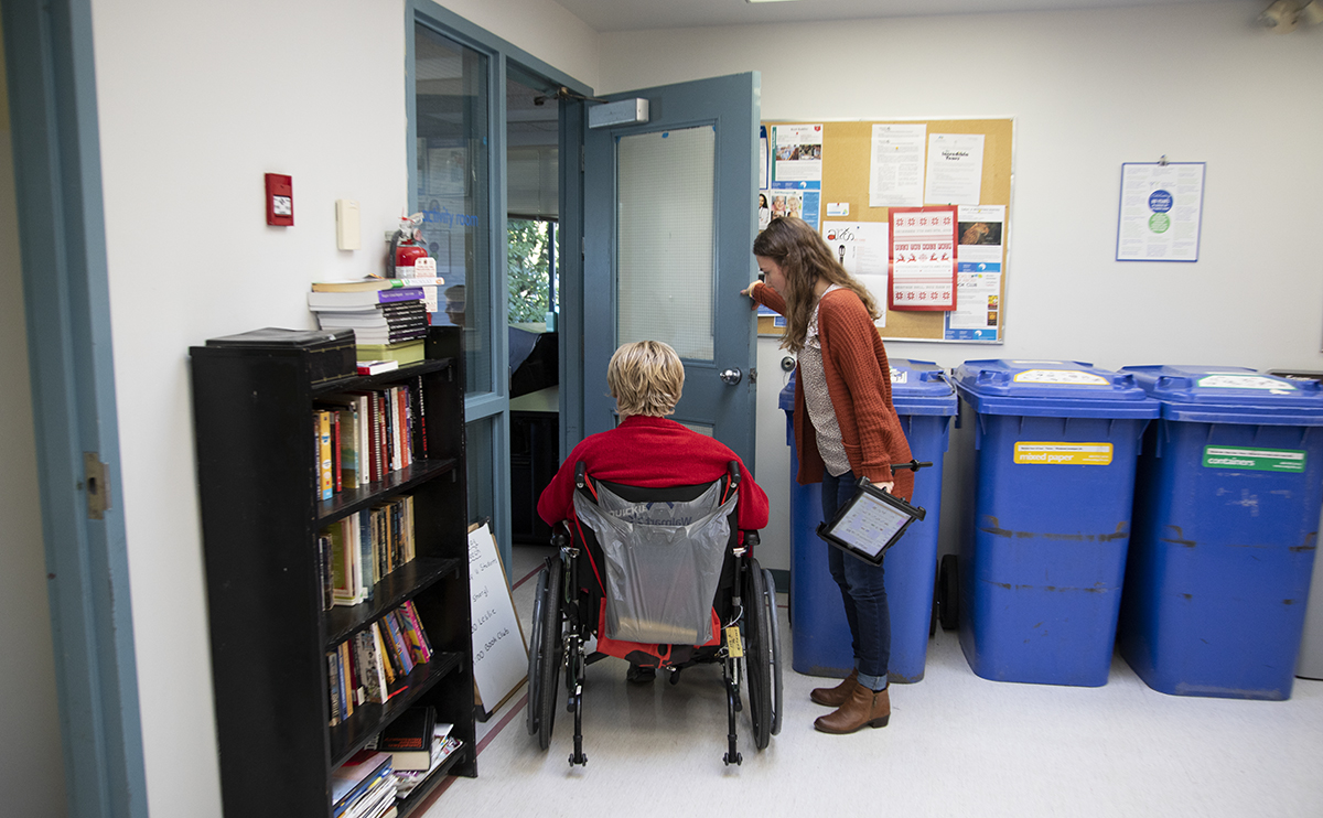 Student opening door for woman in wheelchair