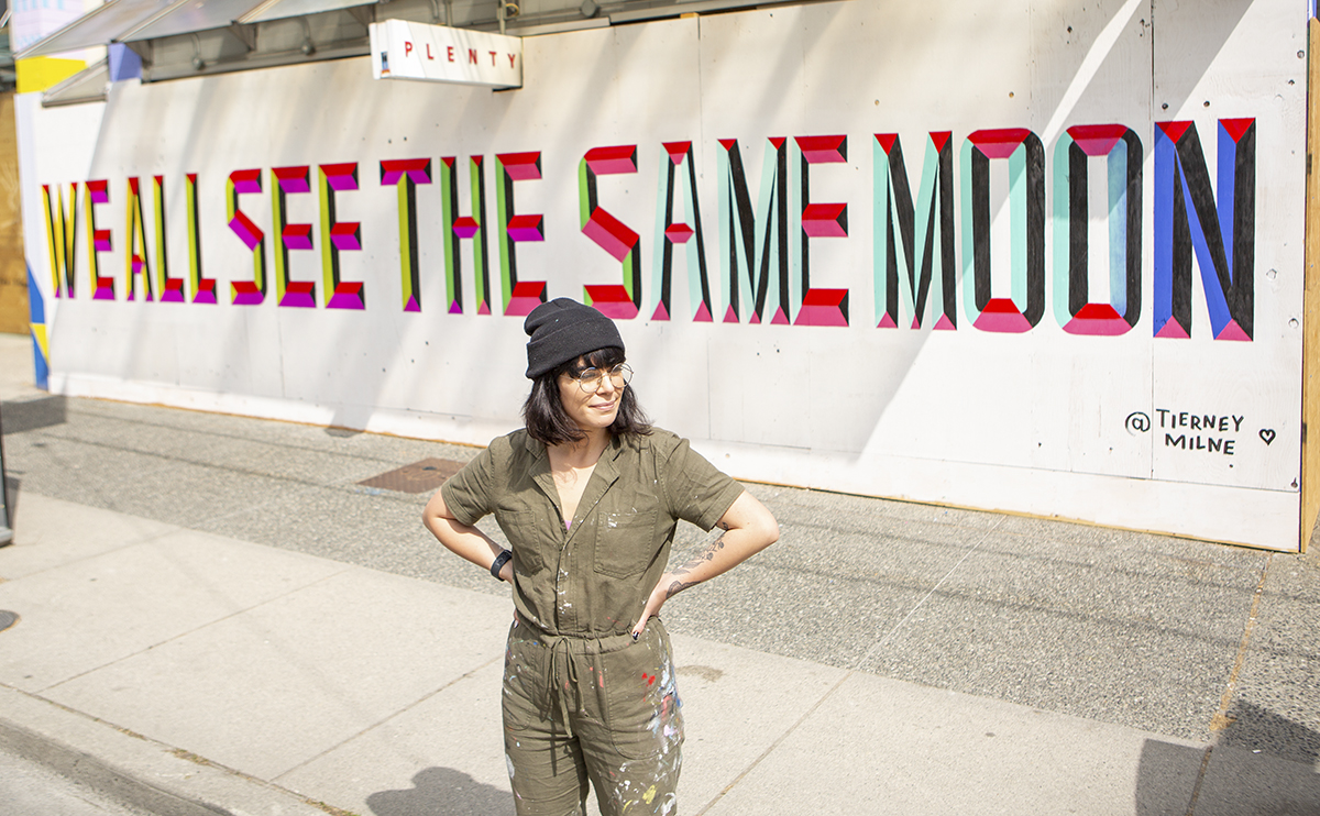 Woman standing in front of mural