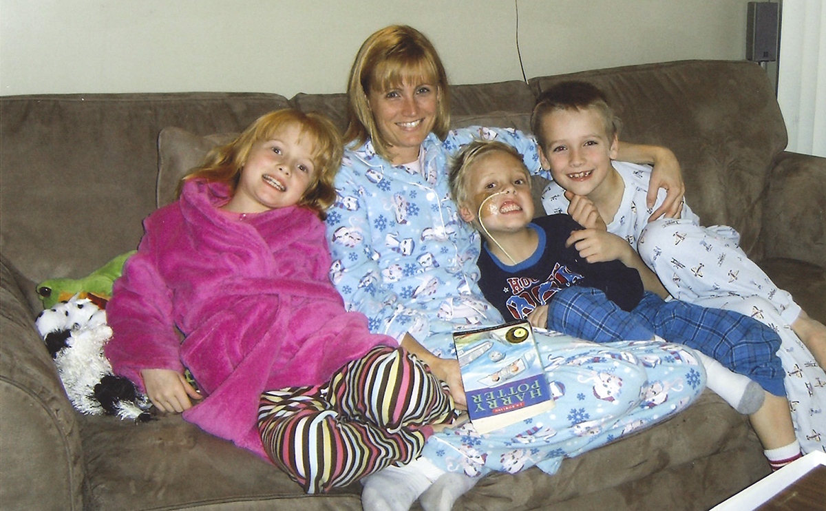 Woman sitting on couch with her three children