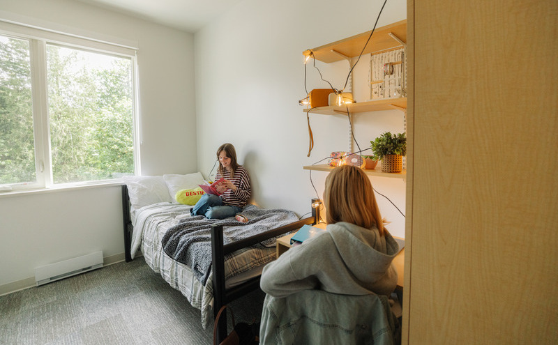 students sitting on the bed in student housing
