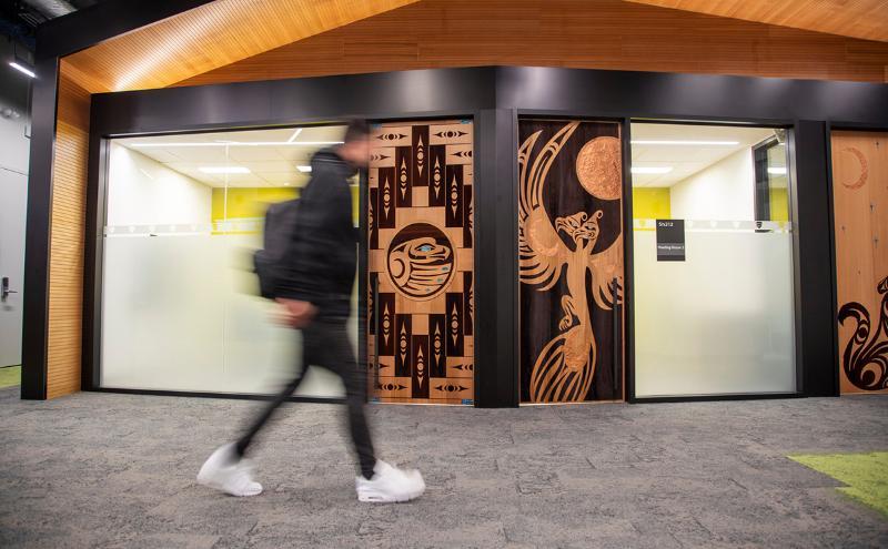 Student walking in front of doors at CapU Lonsdale