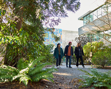 CapU students standing in the forest around North Vancouver campus.