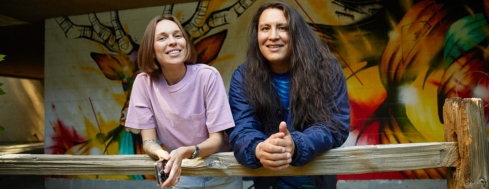 Two CapU students standing in front of a mural.