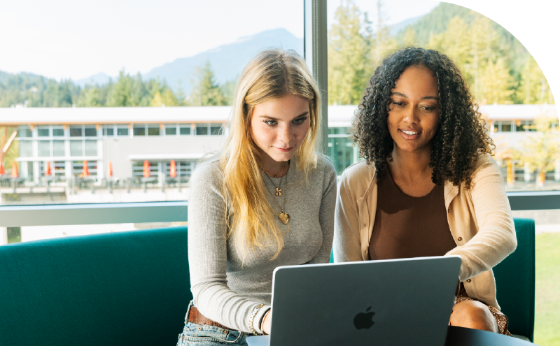 Two students working at a laptop at CapU Squamish.
