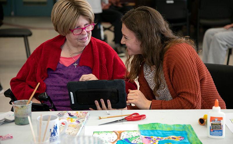 Jo Anthony, left, communicates with CapU student Alecia Ferreira using a tablet device designed to facilitate verbal communication among people with aphasia at the North Shore Neighbourhood House on Wednesday, Nov. 20, 2019. As part of the Unified Grant program, Capilano University students are providing augmentative communication support to North Shore stroke survivors.
