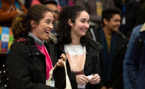 Two students at event on campus laughing 