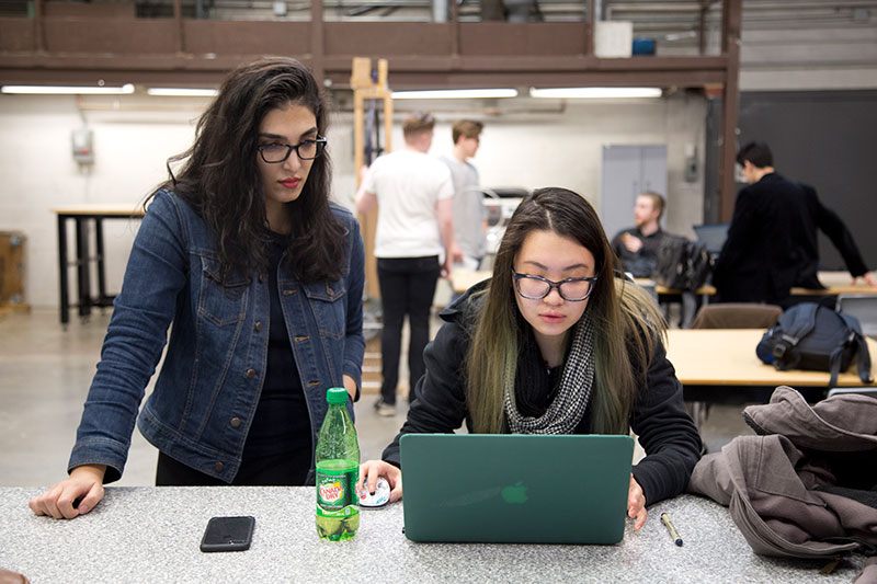 CapU engineering students working at a computer terminal.