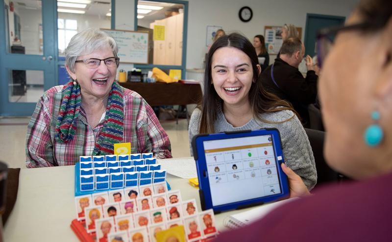 Student playing games with senior client