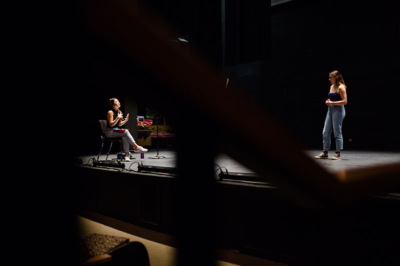 Student getting notes from a director while performing on stage.