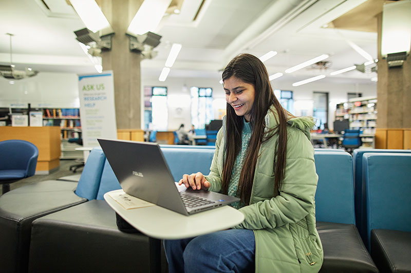 CapU student working at a laptop.