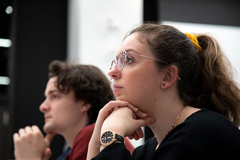 A student listening in one of the Communications classes at CapU.