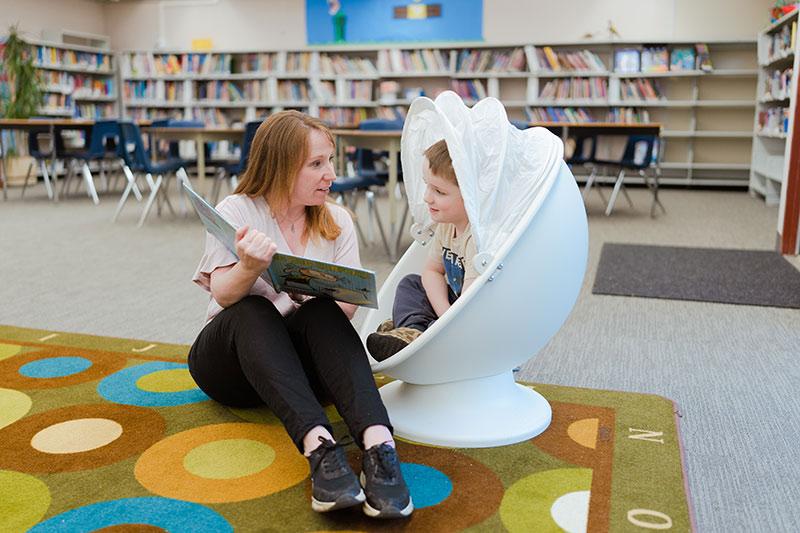 Education Assistant reading a book to a child.