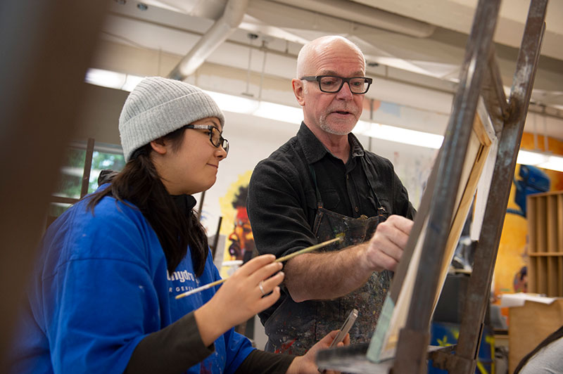 IDEA instructor Jeff Burgess works with a student on her painting.
