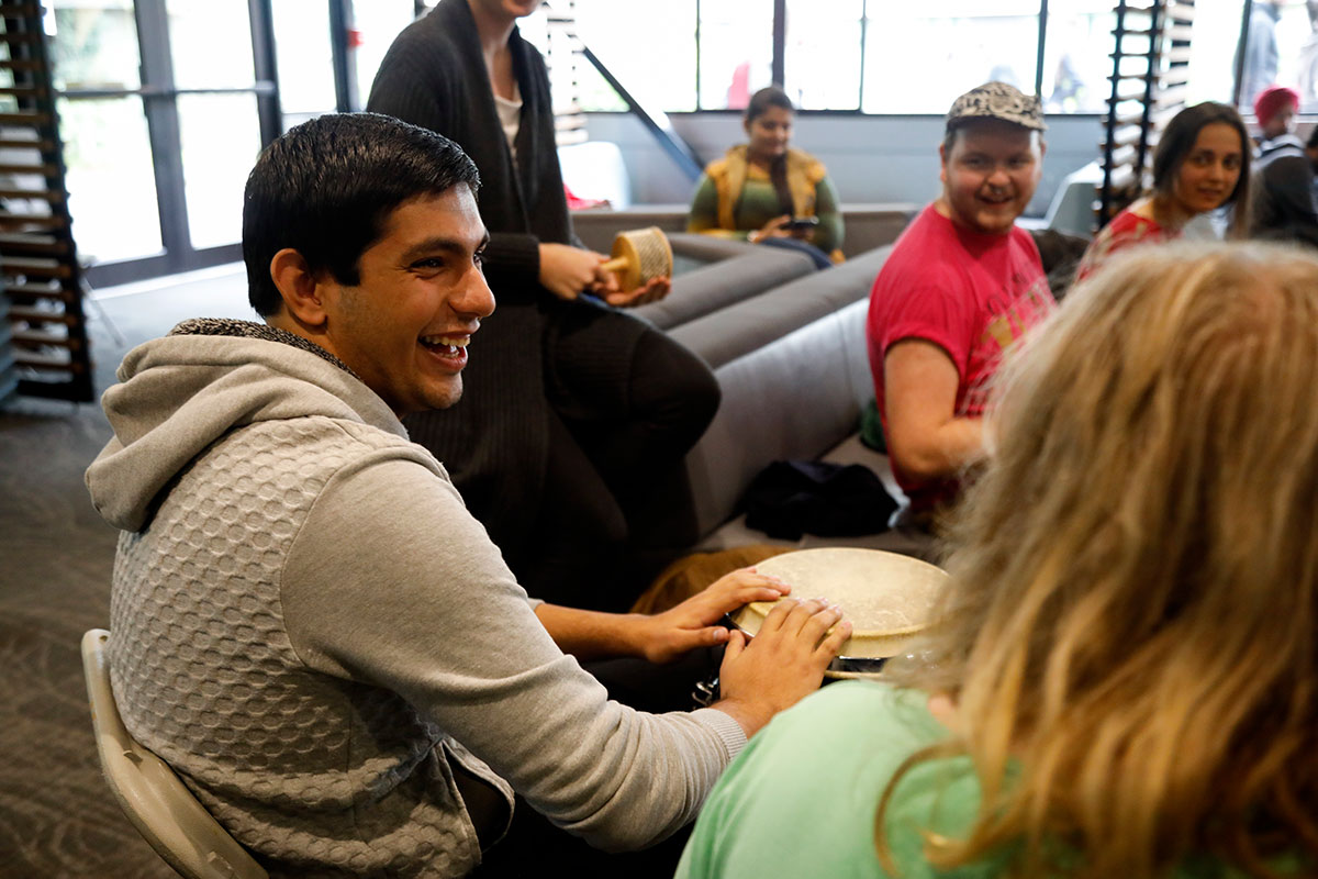 A student participating in a drum circle.