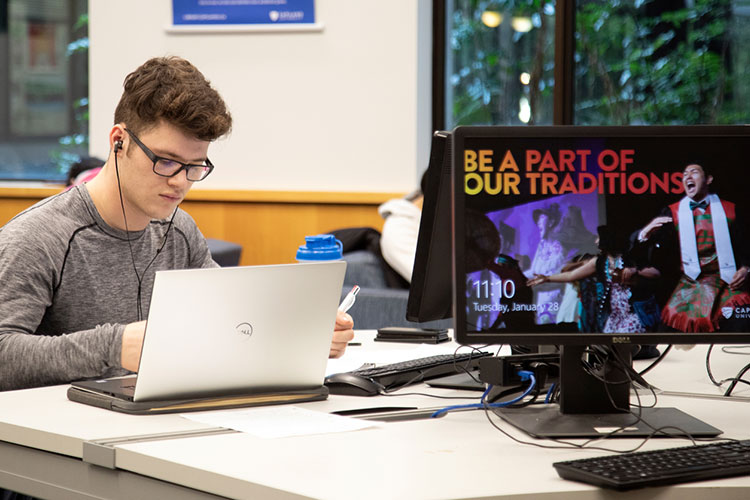 Student on laptop in classroom.