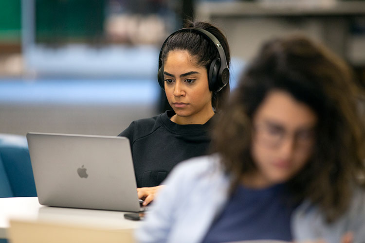 Students in a classroom studying on their laptops.