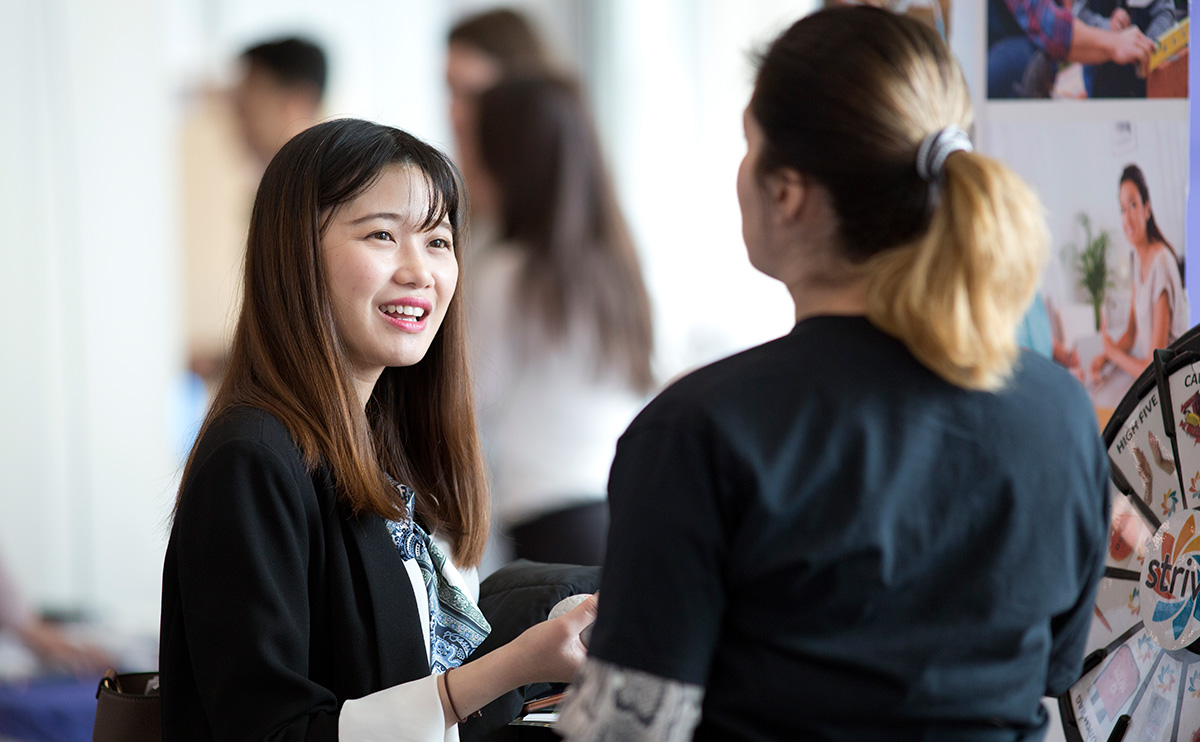 Student talking to someone at a networking event