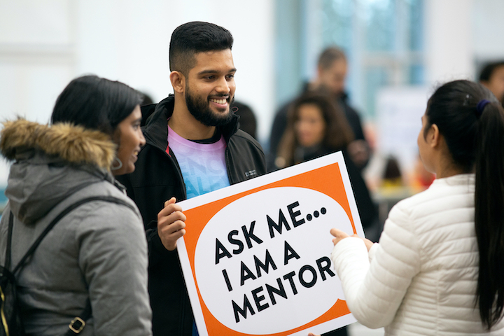 Student holding sign saying they are a mentor