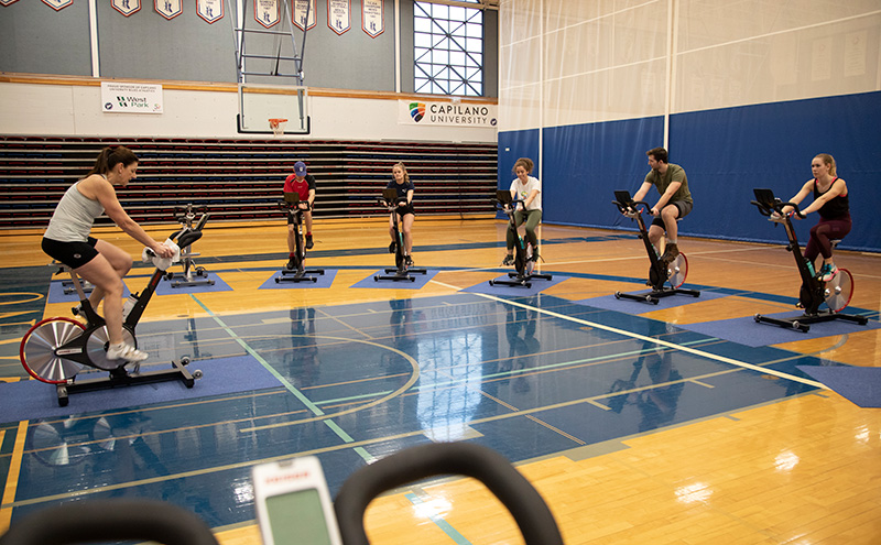 Students in the gymnasium on stationery bikes