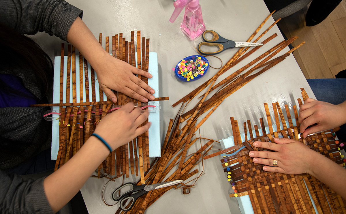 Students make regalia for Convocation in the Kéxwusm-áyakn Student Centre