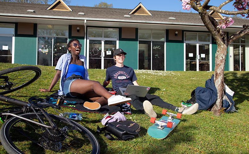 Students sitting outside beside bike